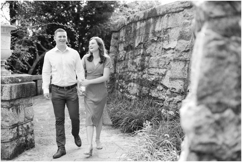 Black and white photo of a couple walking on a stone-walled path