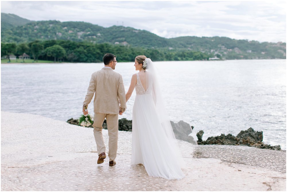 Couple walks by the shore at their Caribbean wedding