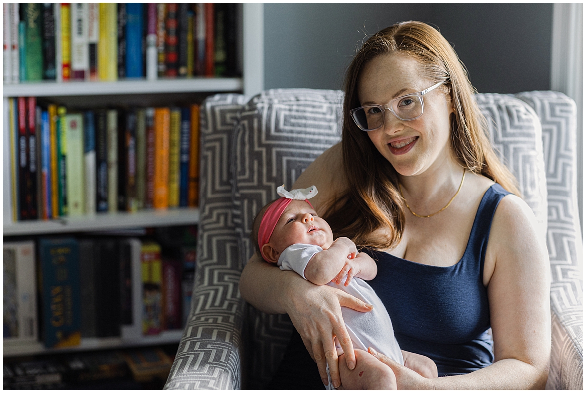 Mom Holding Baby in Chair at Home Newborn Photoshoot