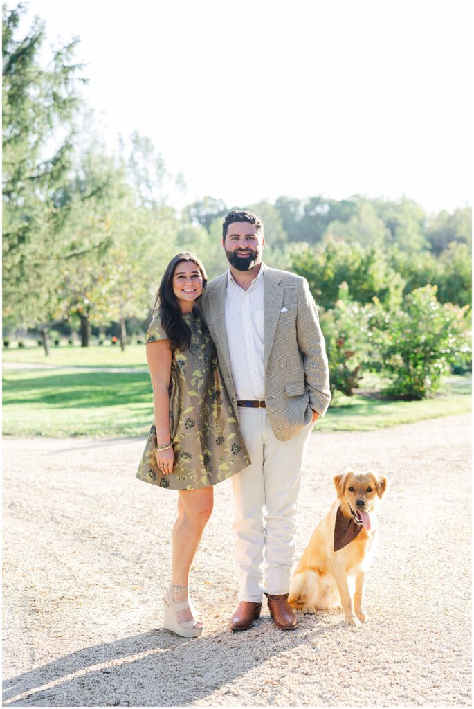Preserve At Dundee engagement session. Girl is wearing a green dress, man is wearing a blazer and there is a golden retriever dog in the picture.