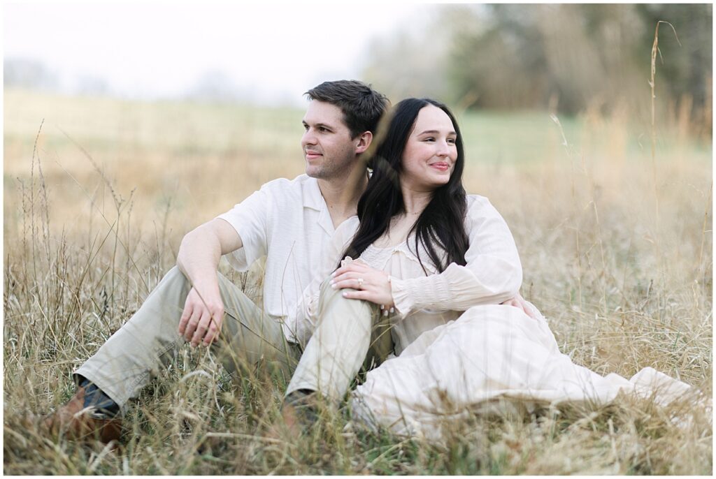 Countryside engagement session with the couple relaxing in a field