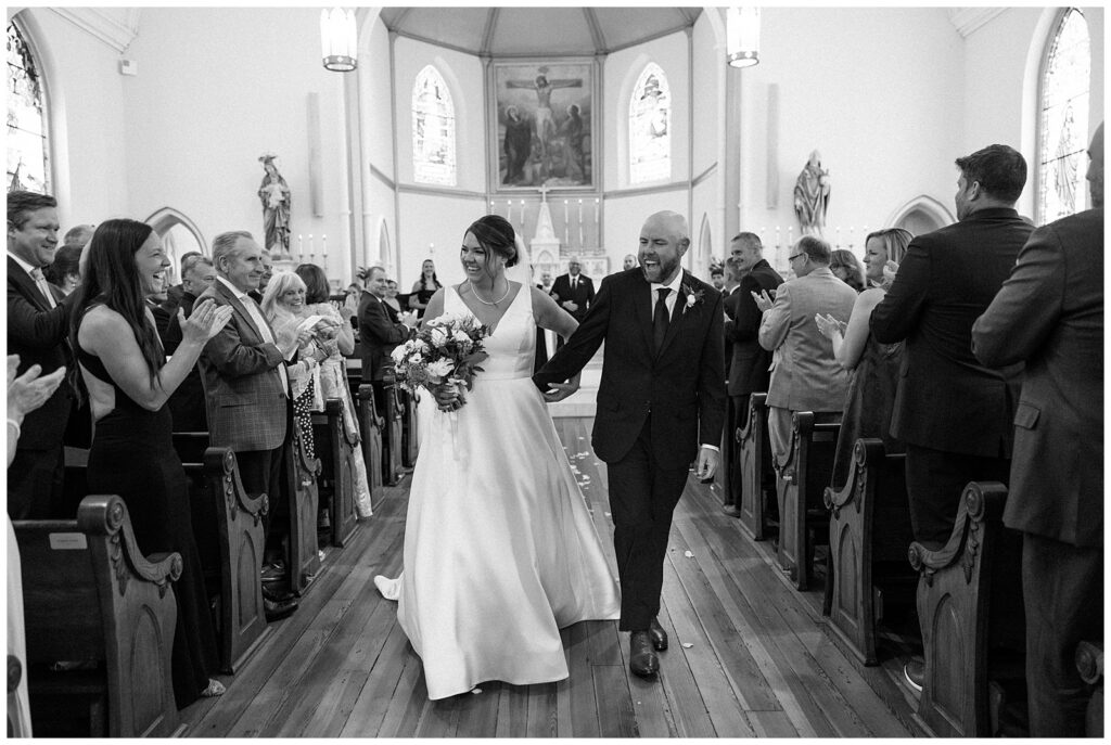 Bride and Groom Walk Down Aisle of Church as Married Couple