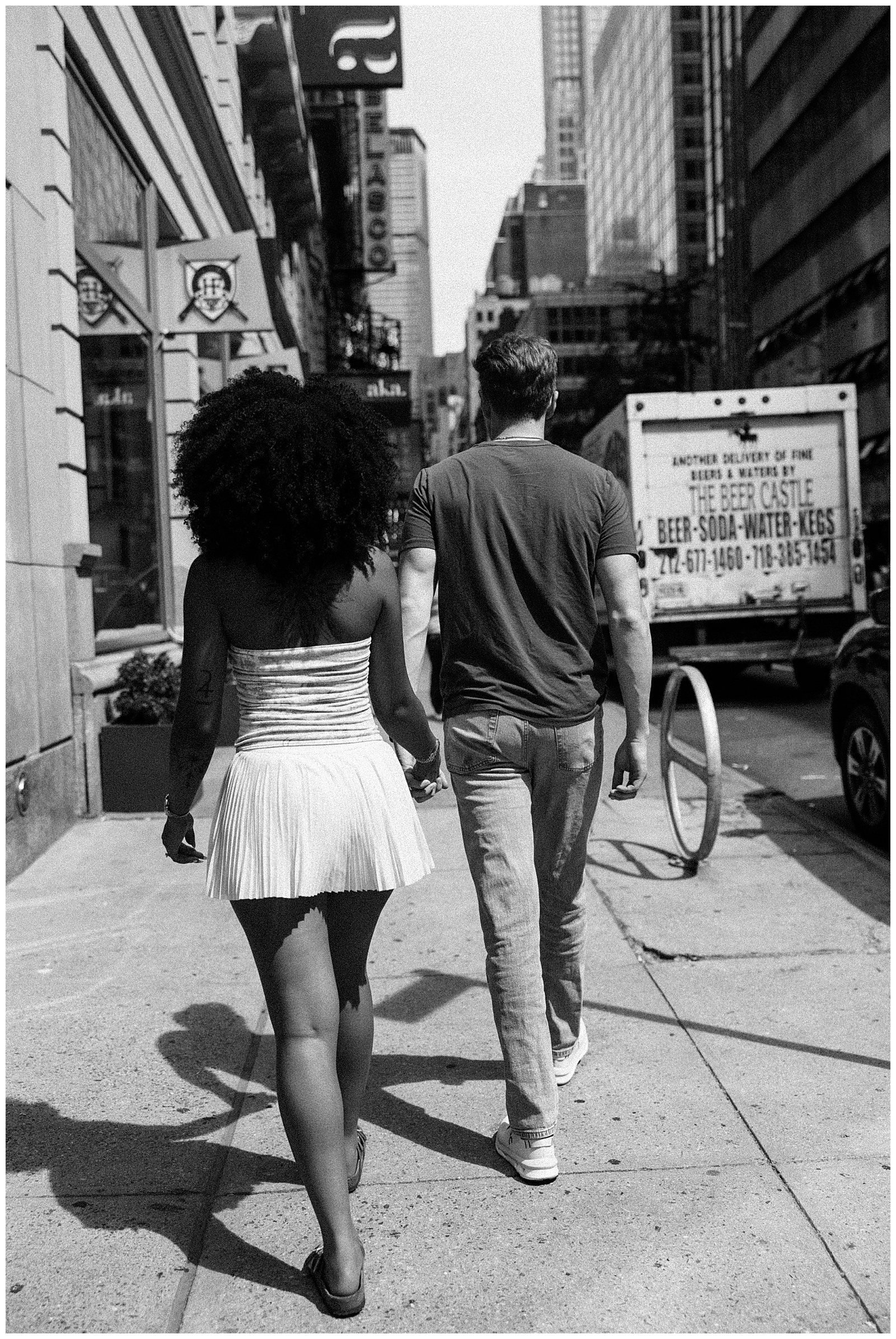 Black and White Photo of Couple Holding Hands Navigating Busy Sidewalk in New York