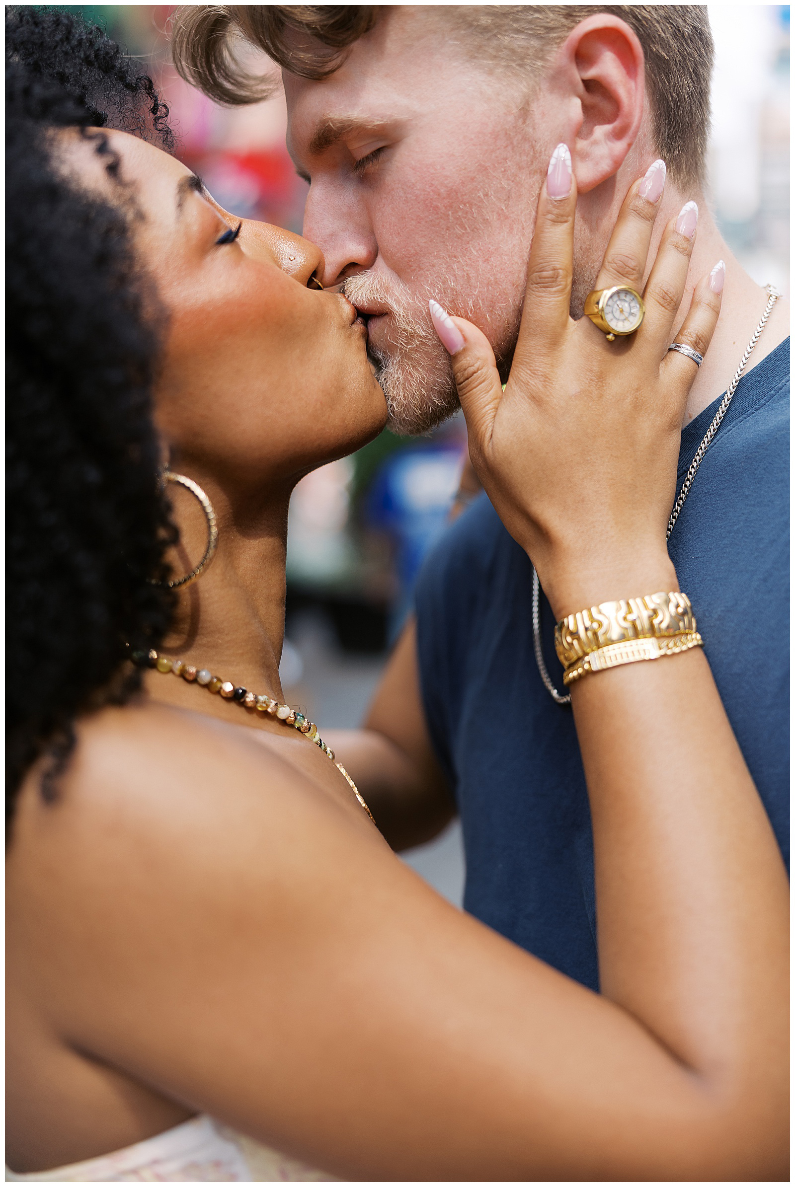 An up close portrait of a couple kissing in Time Square. 