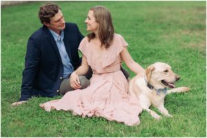 Formal engagement photos with a couple sitting on the grass with their dog